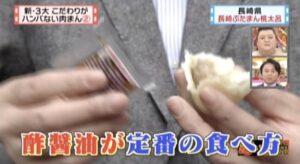 ぶたまんに酢醤油をつけている様子
